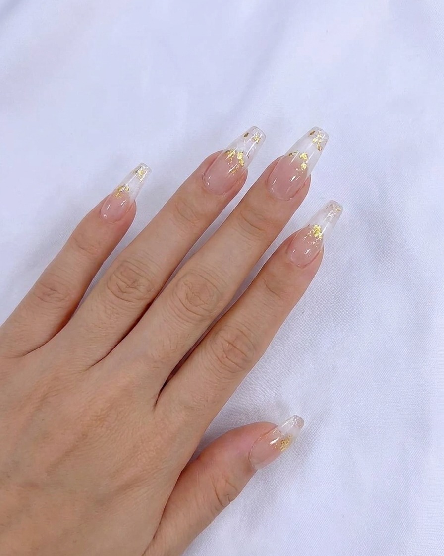 Un pennellino applica uno strato uniforme di smalto gel semipermanente nude sullunghia naturale.