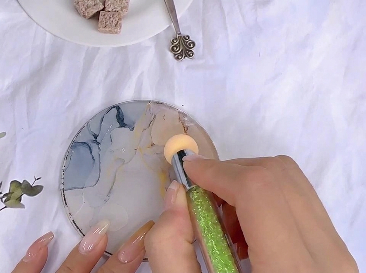 Una spugnetta viene tamponata nel gel colorato steso su una tavolozza in vetro.