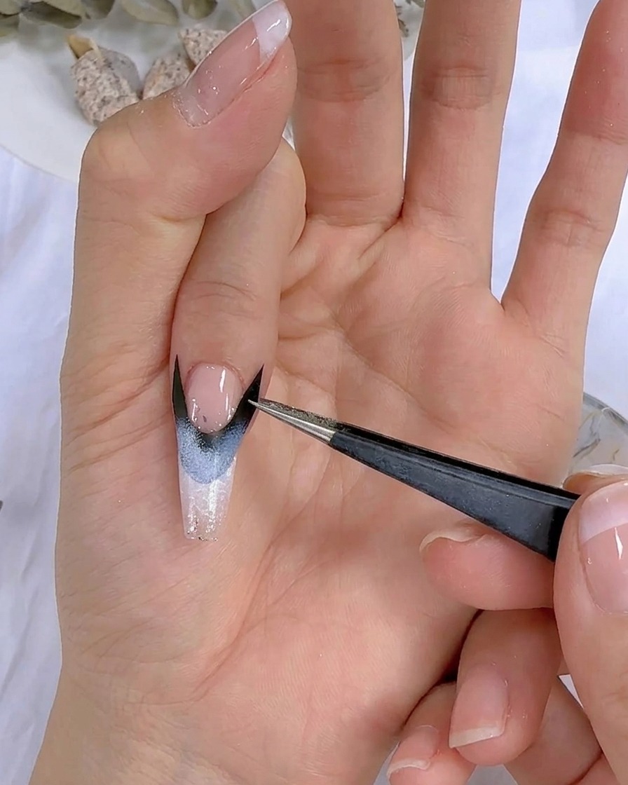 Primo piano di una mano con nail art posizionata sotto una lampada UV LED.