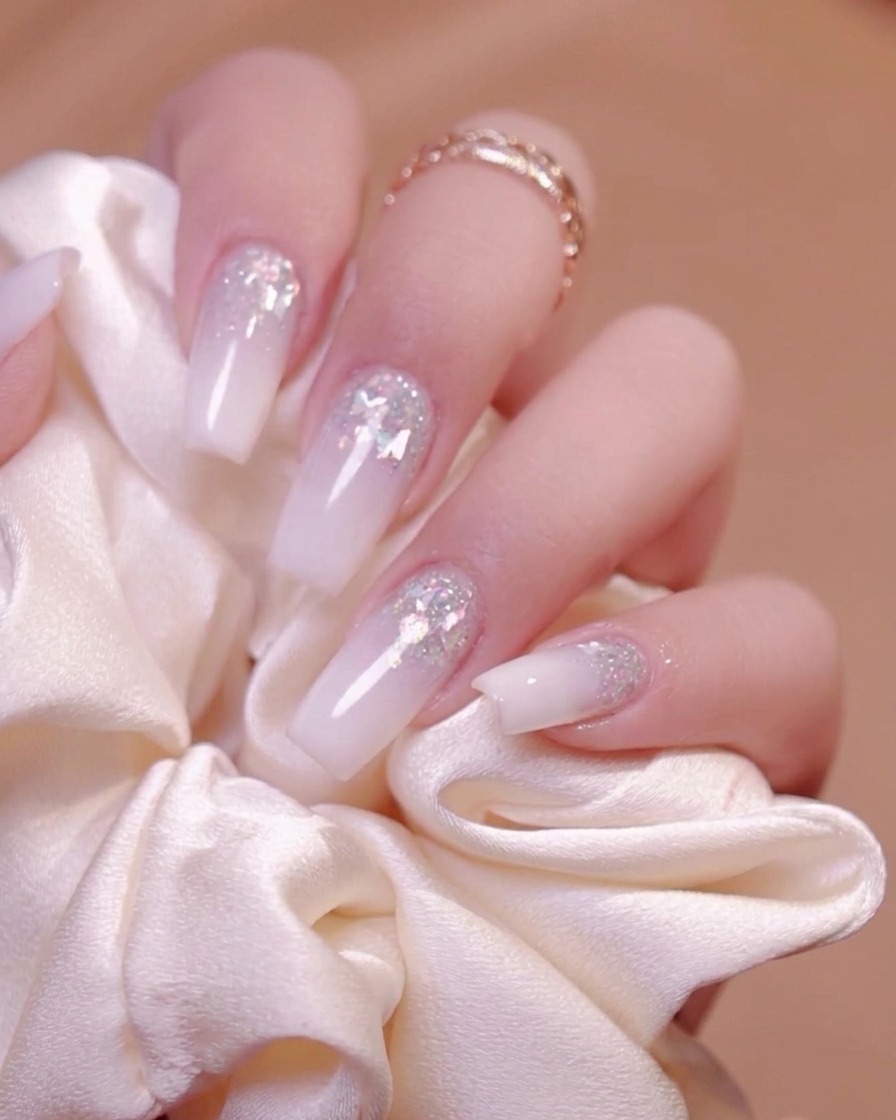 Una spazzola rigida da manicure che spazza via la polvere dalle scanalature delle unghie.