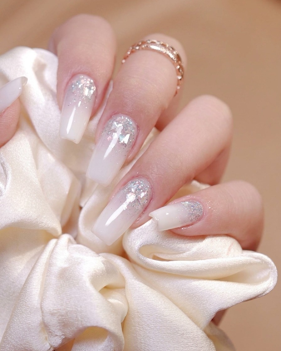Un pennello che applica uniformemente un top coat lucido sulla superficie di ununghia decorata.