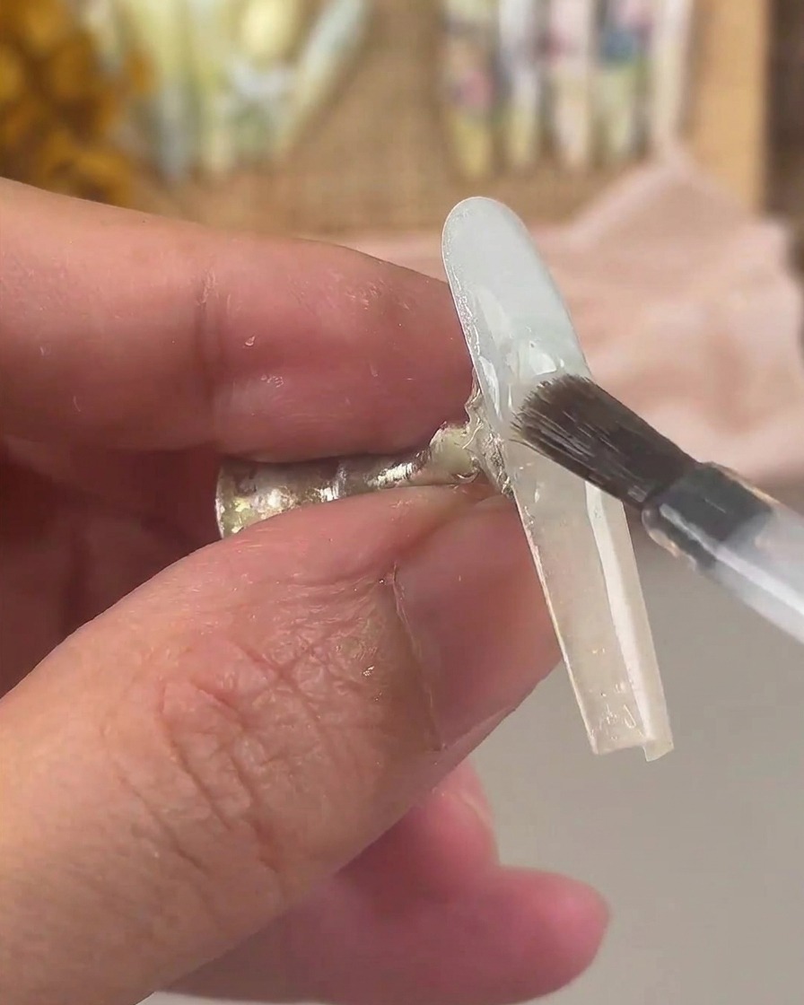 Un pennello da unghie che copre lunghia rifinita con la sfumatura con uno strato di gel base trasparente.