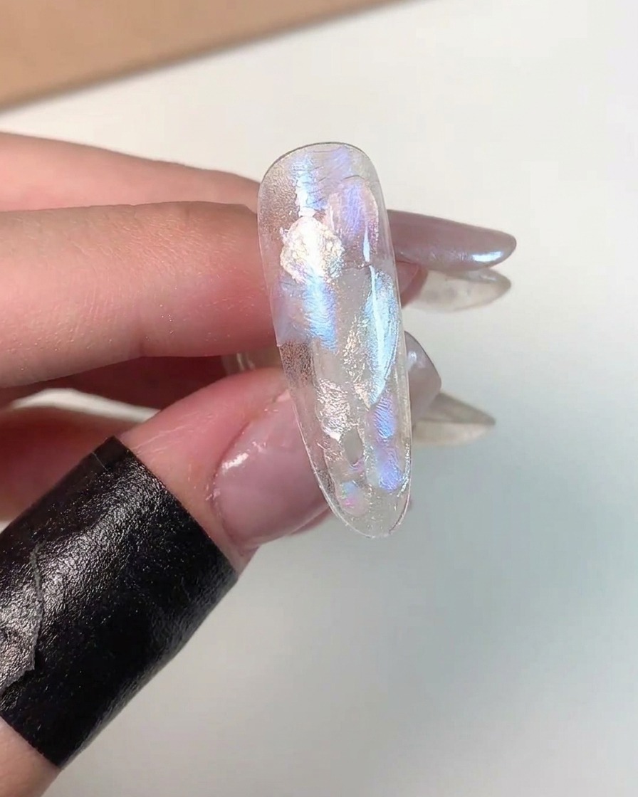 Un primo piano che mostra il gel cat eye magnetizzato nellangolo inferiore di una tip per unghie di prova.