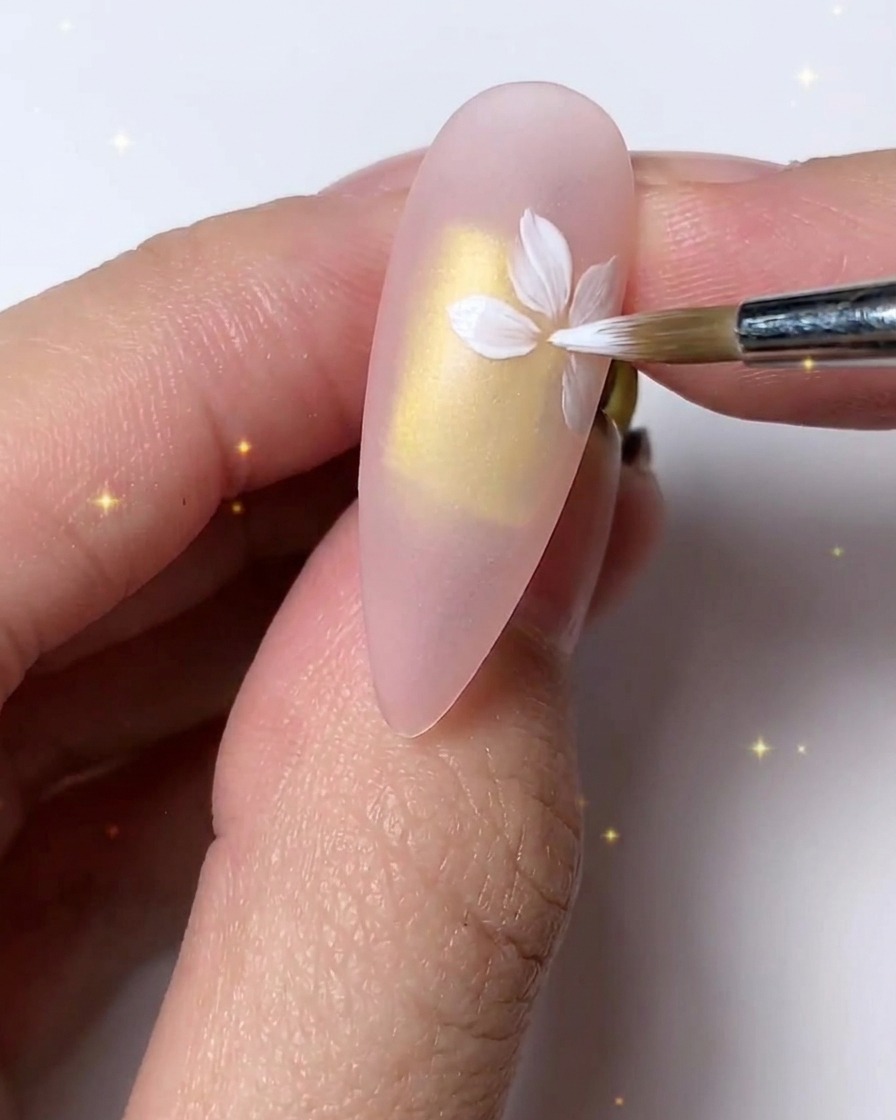 Un pennello fine che rifinisce e stratifica i petali bianchi per un look delicato sullunghia.
