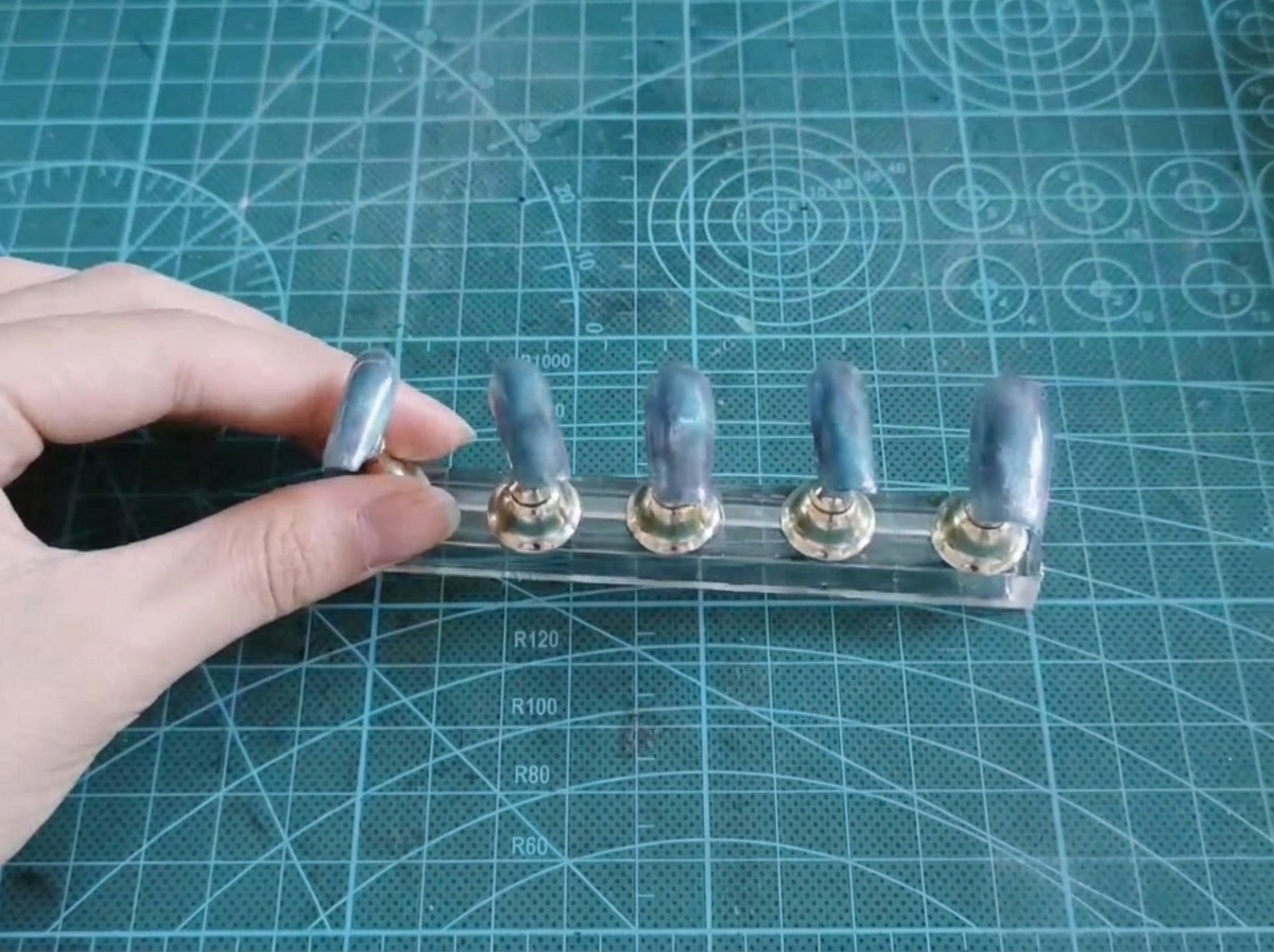 Cinque tip su un supporto mostrano una base sfumata blu e viola completata.