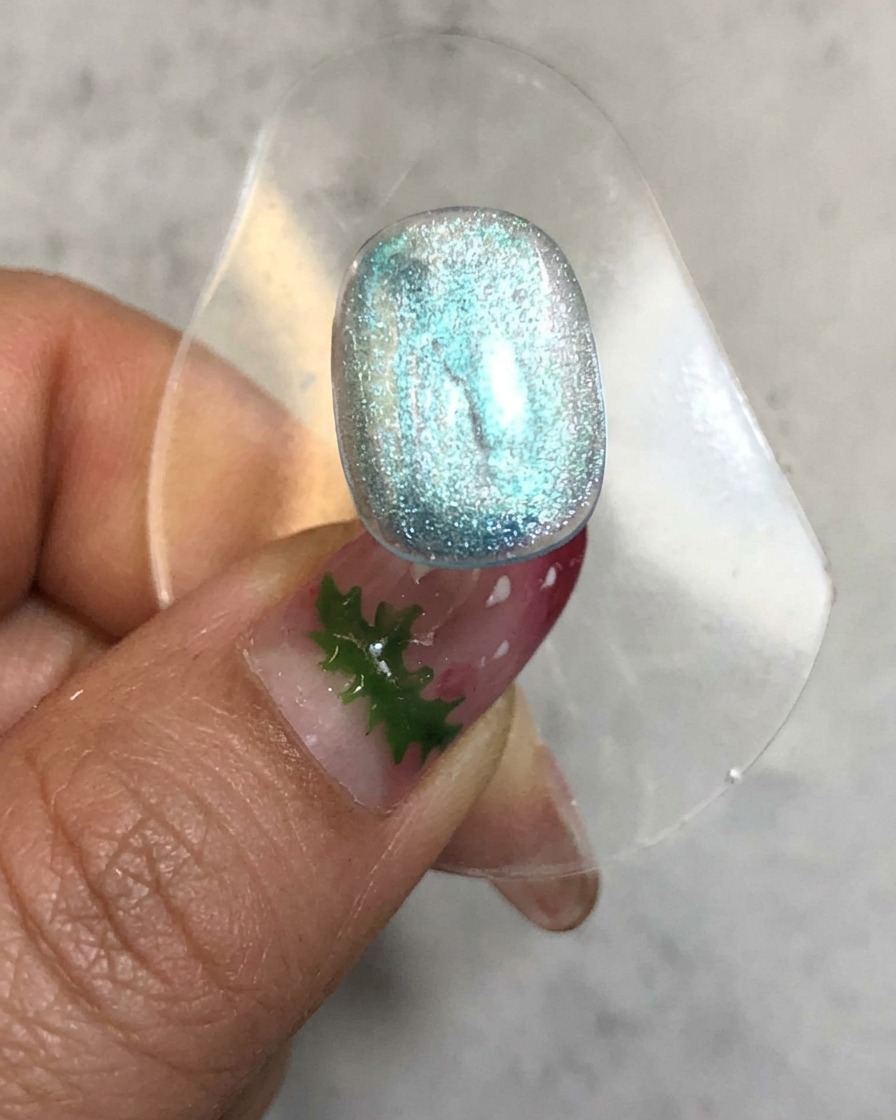 Ununghia inserita allinterno di una lampada di polimerizzazione con una luce brillante emessa attorno alla superficie del gel blu traslucido.