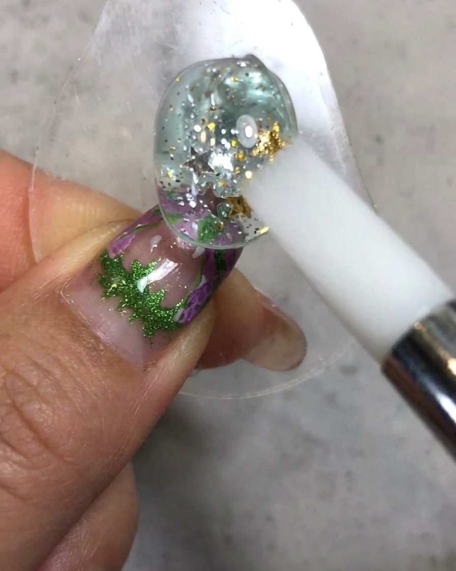 Una penna in silicone bianca che modella e leviga la consistenza del soft candy gel sulla superficie dellunghia decorata.