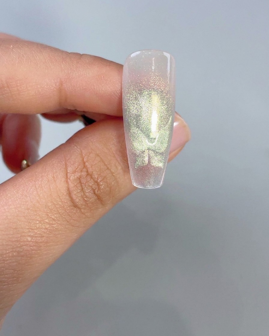 Primo piano di una tip trasparente che mostra forme di ali di farfalla cat-eye verdi luminose dopo lattivazione magnetica.