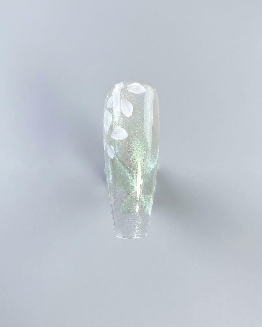 Una composizione floreale completa di petali dipinti di bianco su uno sfondo cat-eye trasparente prima della colorazione.