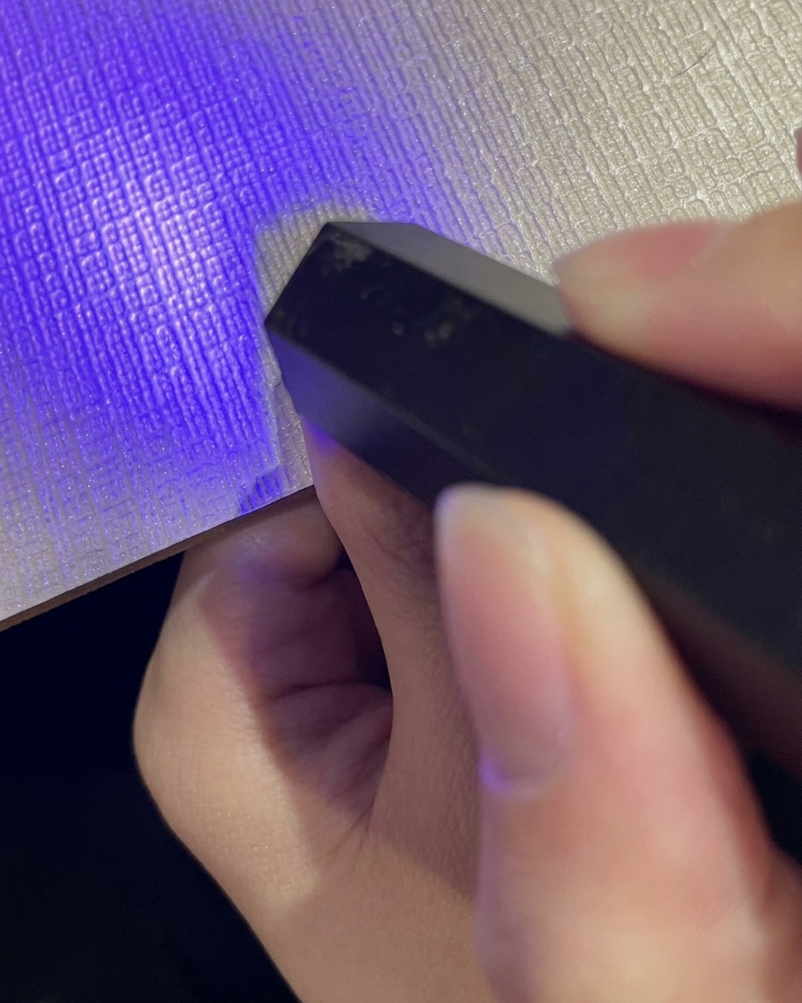 Applicazione di una mano di smalto gel glitterato cat eye riflettente sopra lunghia sfumata.