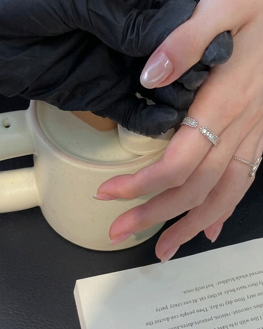 Un pennello che applica uno strato di top coat trasparente sopra una manicure cat eye completata.