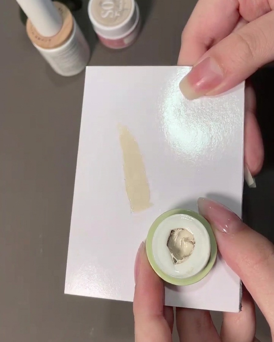 Una spugnetta che preleva del gel di riempimento bianco latte da una tavolozza.