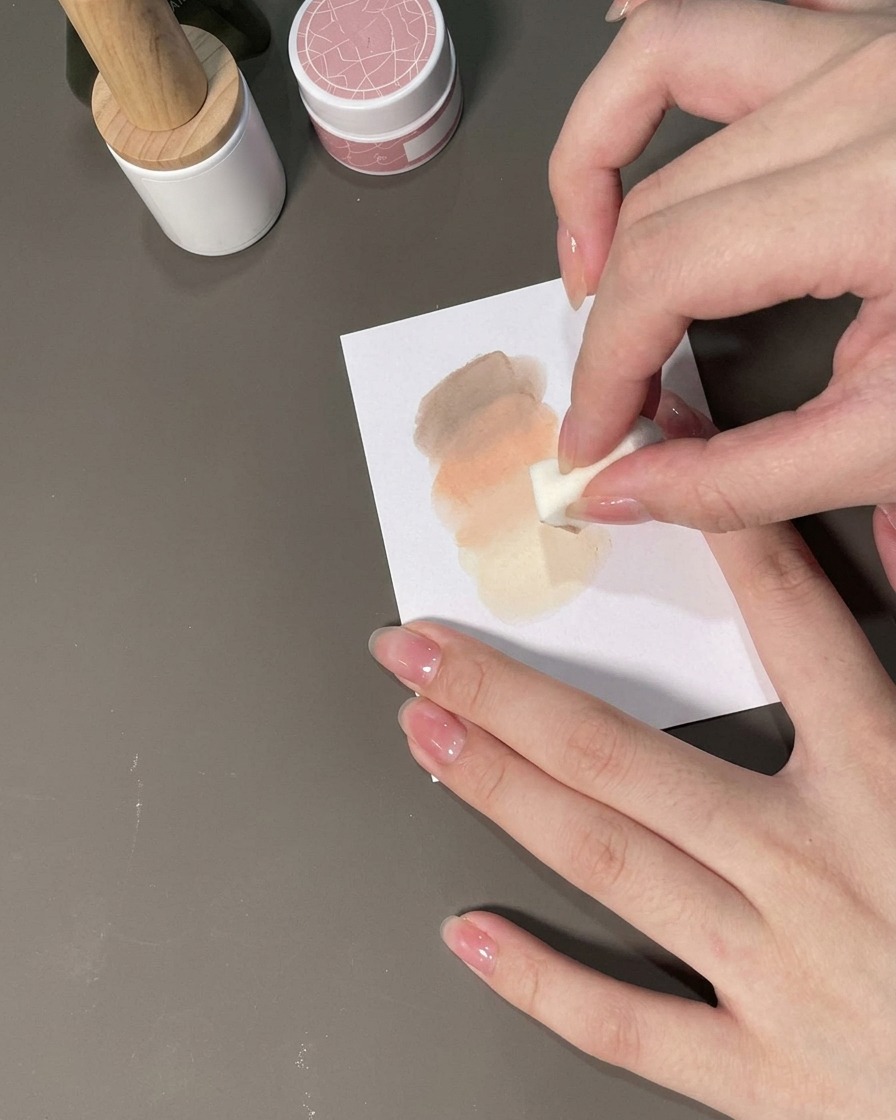 Una spugnetta che tampona il gel su ununghia per formare una sfumatura ombré.