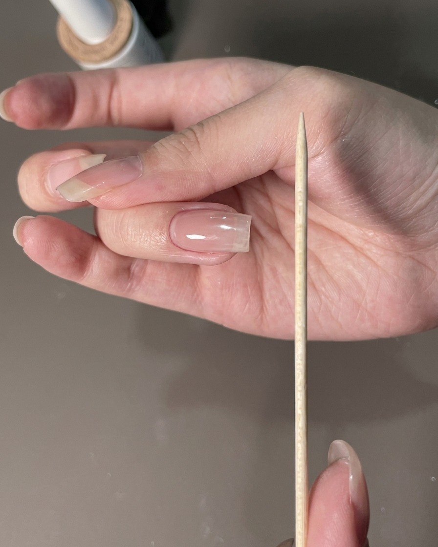 Una lima per unghie tenuta vicino a una mano curata per modellare i bordi dellunghia.