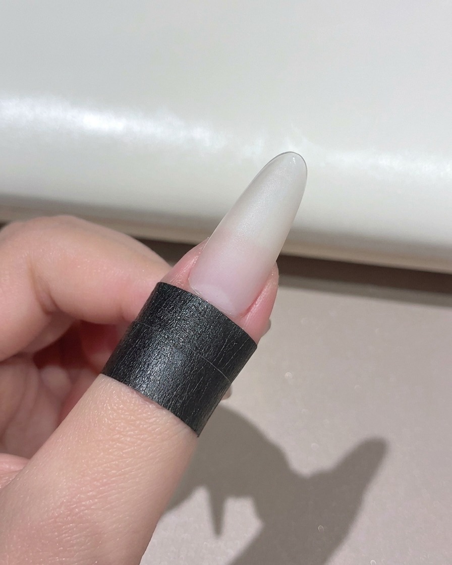 Ununghia curata posizionata sotto una lampada UV LED portatile compatta.