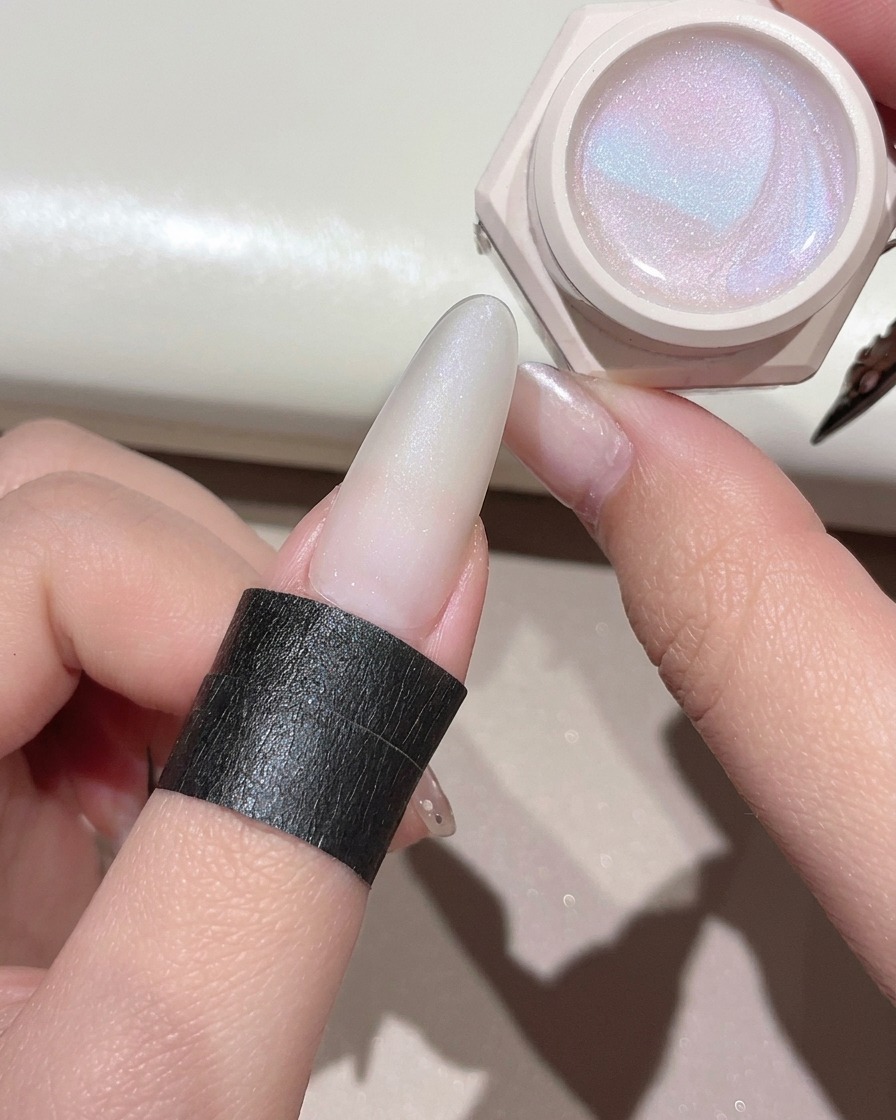 Un pennello da gel che applica un gel cat-eye trasparente e brillante sullunghia preparata.