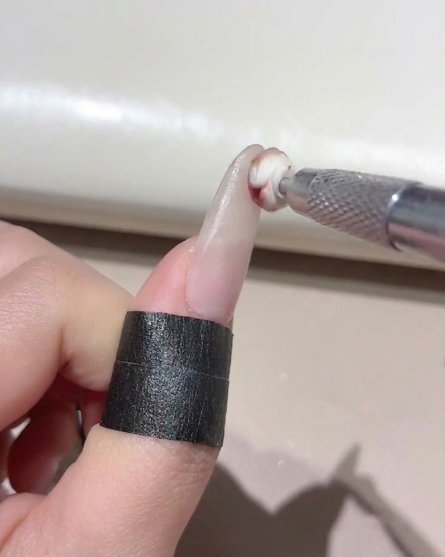 Un piccolo strumento in spugna che tampona il gel misto sulla punta di ununghia curata.