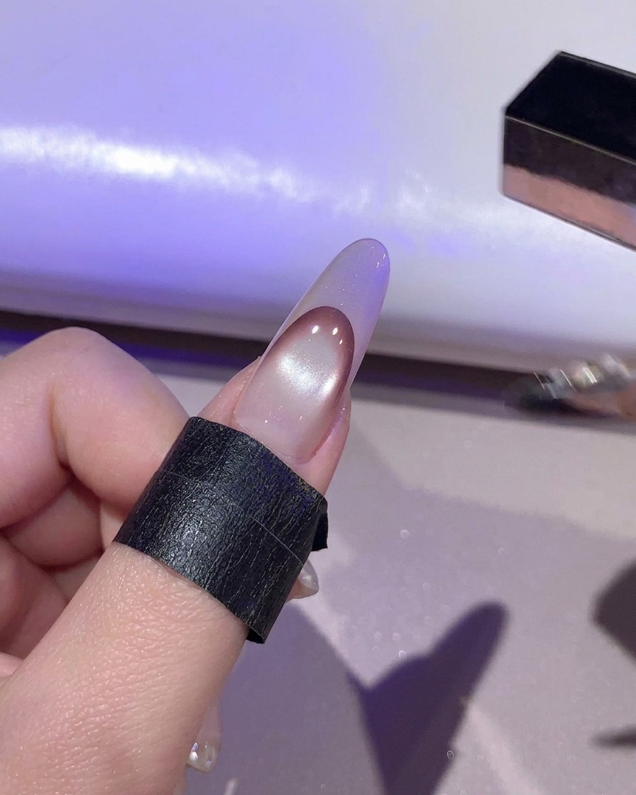 Ununghia in fase di polimerizzazione sotto la luce viola allinterno di una lampada UV/LED.