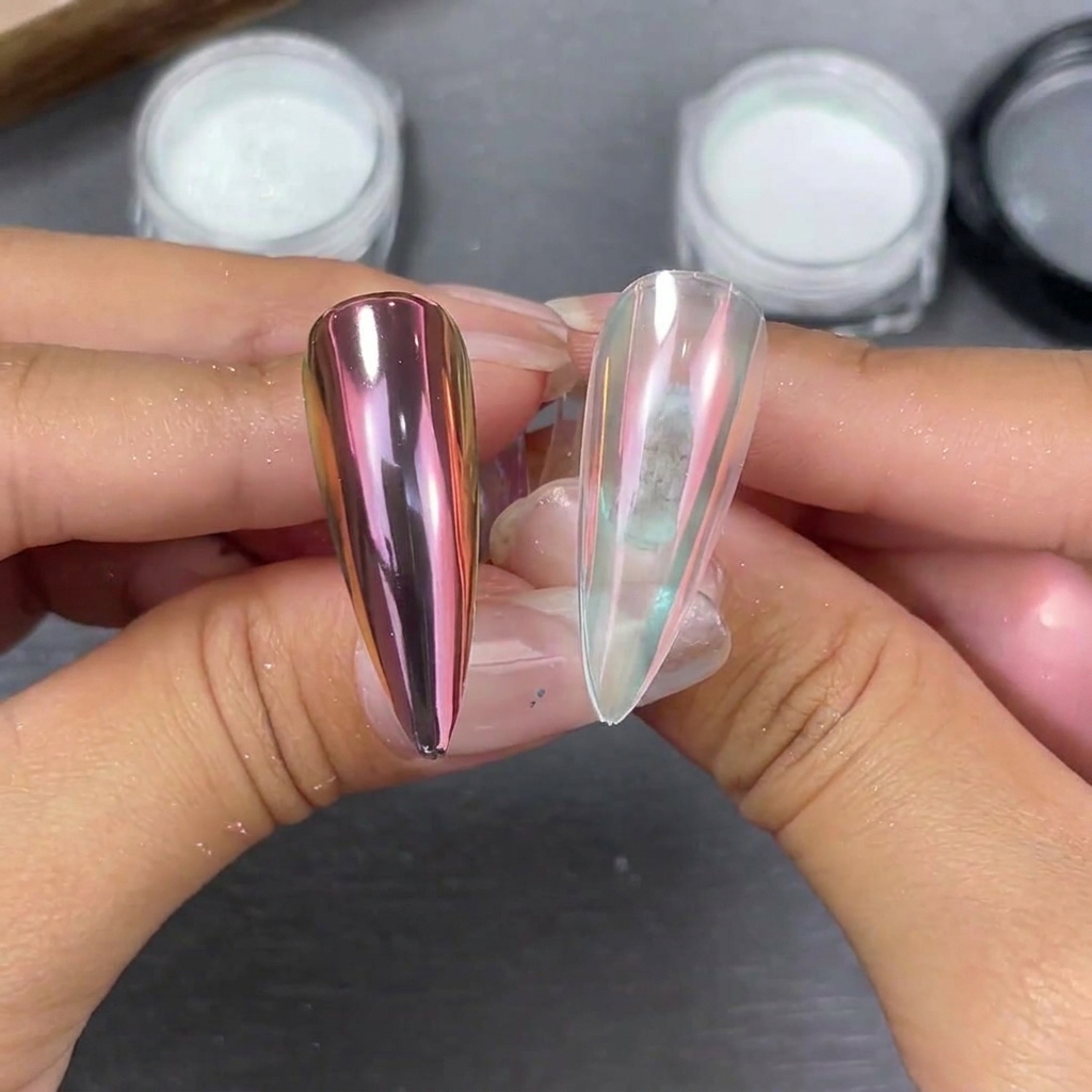 Due punte per unghie a stiletto tenute fianco a fianco che mostrano gli effetti della polvere moonlight: una sfumatura rosa-viola su base nera e una morbida lucentezza perlata su base trasparente.