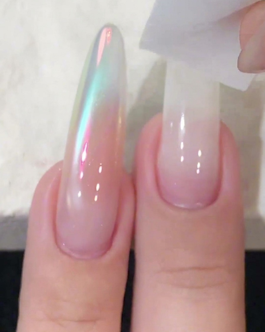 Un blocchetto spugna utilizzato per tamponare e sfumare lo smalto gel bianco su unestensione ungueale lunga.