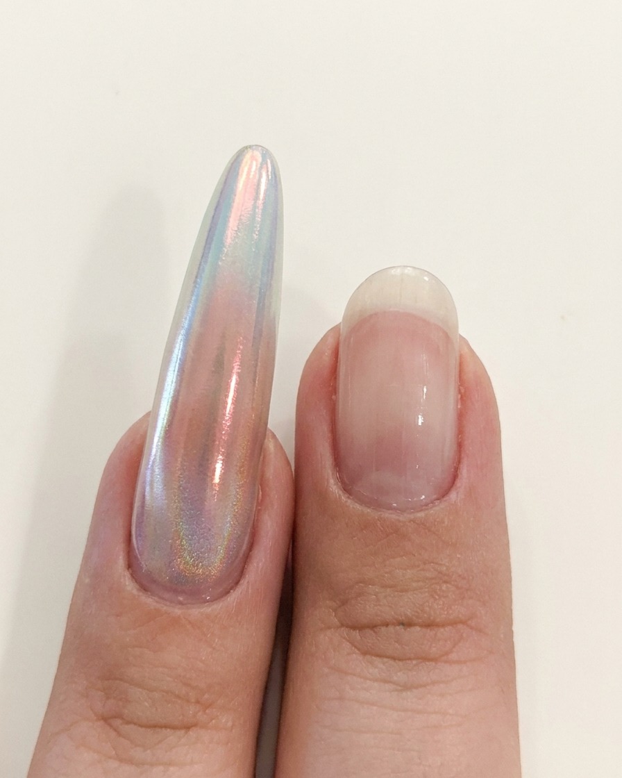 Una mano posizionata vicino a una lampada UV/LED per polimerizzare lapplicazione sulle unghie.
