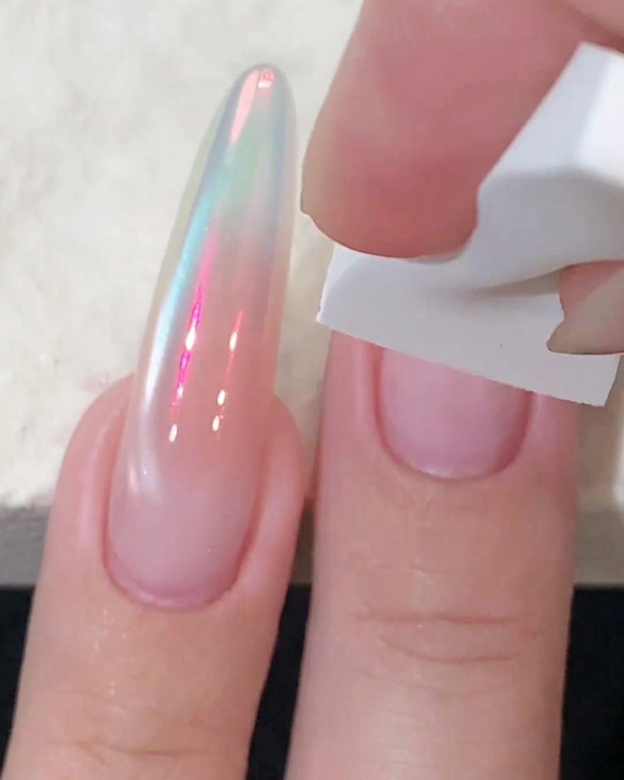 Una spugnetta bianca che tampona il gel rosa blush al centro di ununghia per intensificarne il colore.