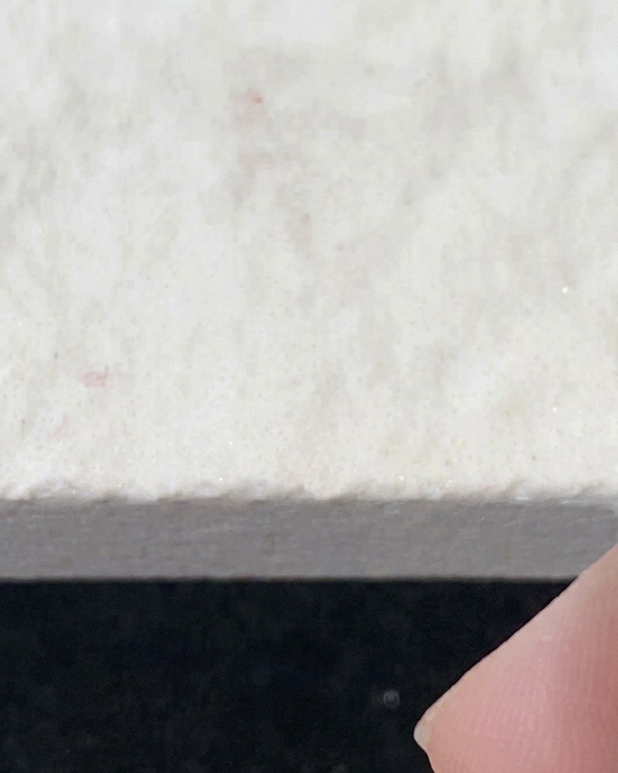 Un pennello che applica il top coat water-gloss trasparente su una superficie ungueale preparata.