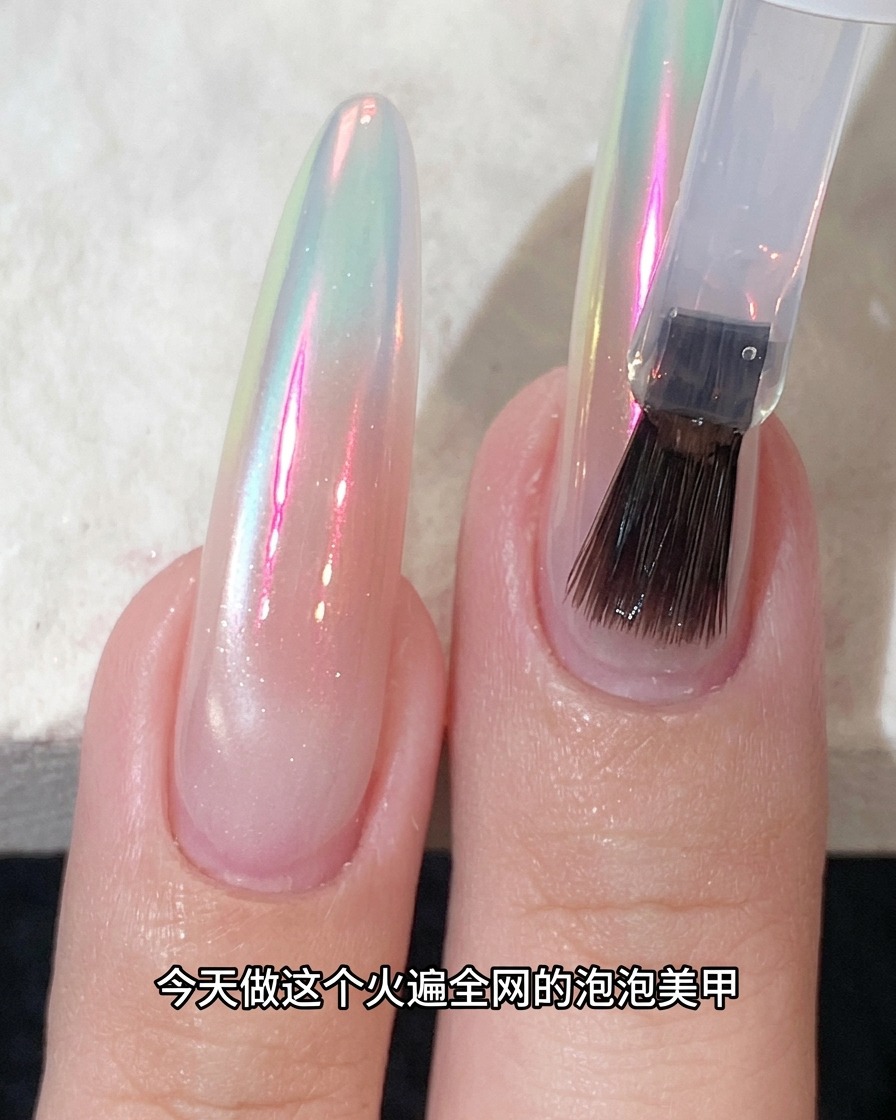 Un pennello che applica il top coat su ununghia rifinita con effetto cromo scintillante.