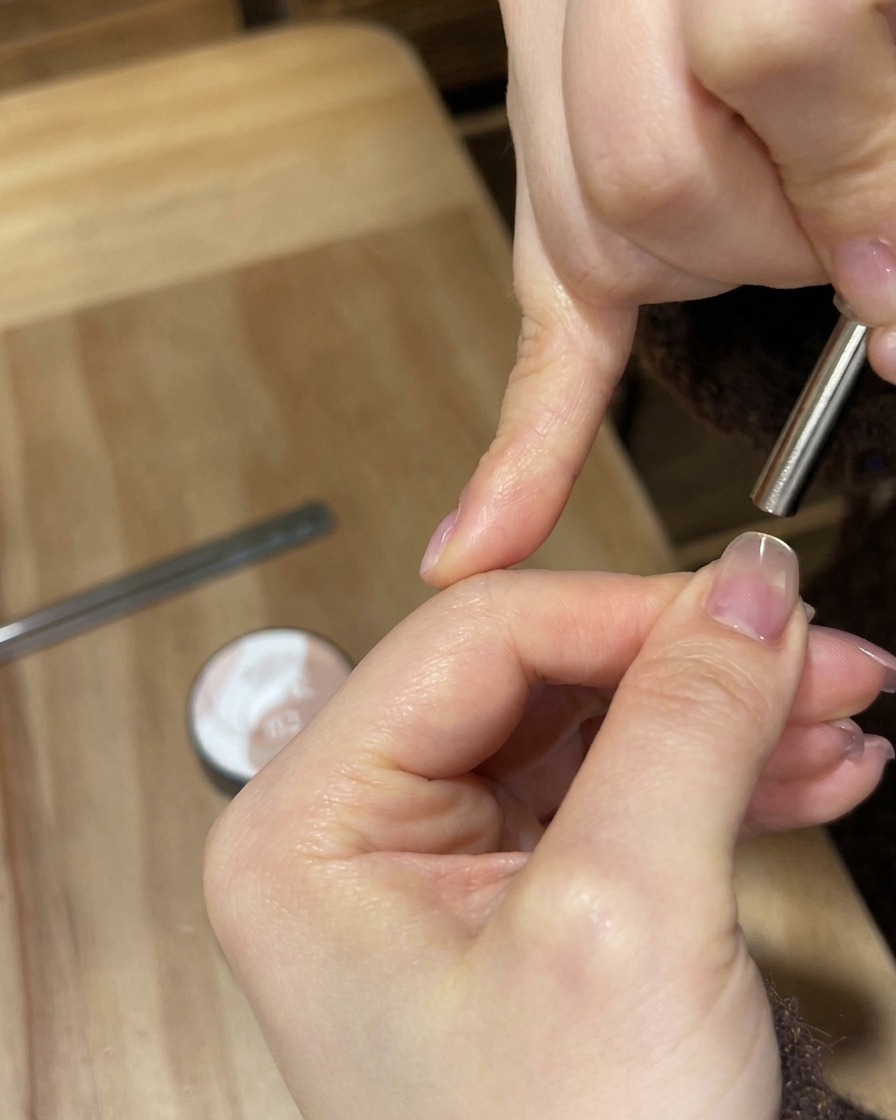 Una lampada portatile bianca UV/LED illumina ununghia per polimerizzare il rivestimento in gel.