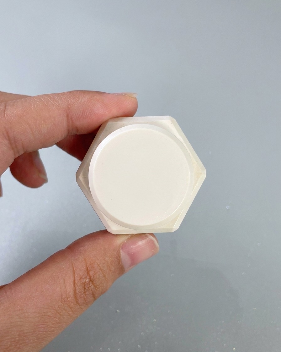 Una spugnetta per make-up che tampona il gel da pittura bianco sui bordi della superficie di ununghia dipinta.