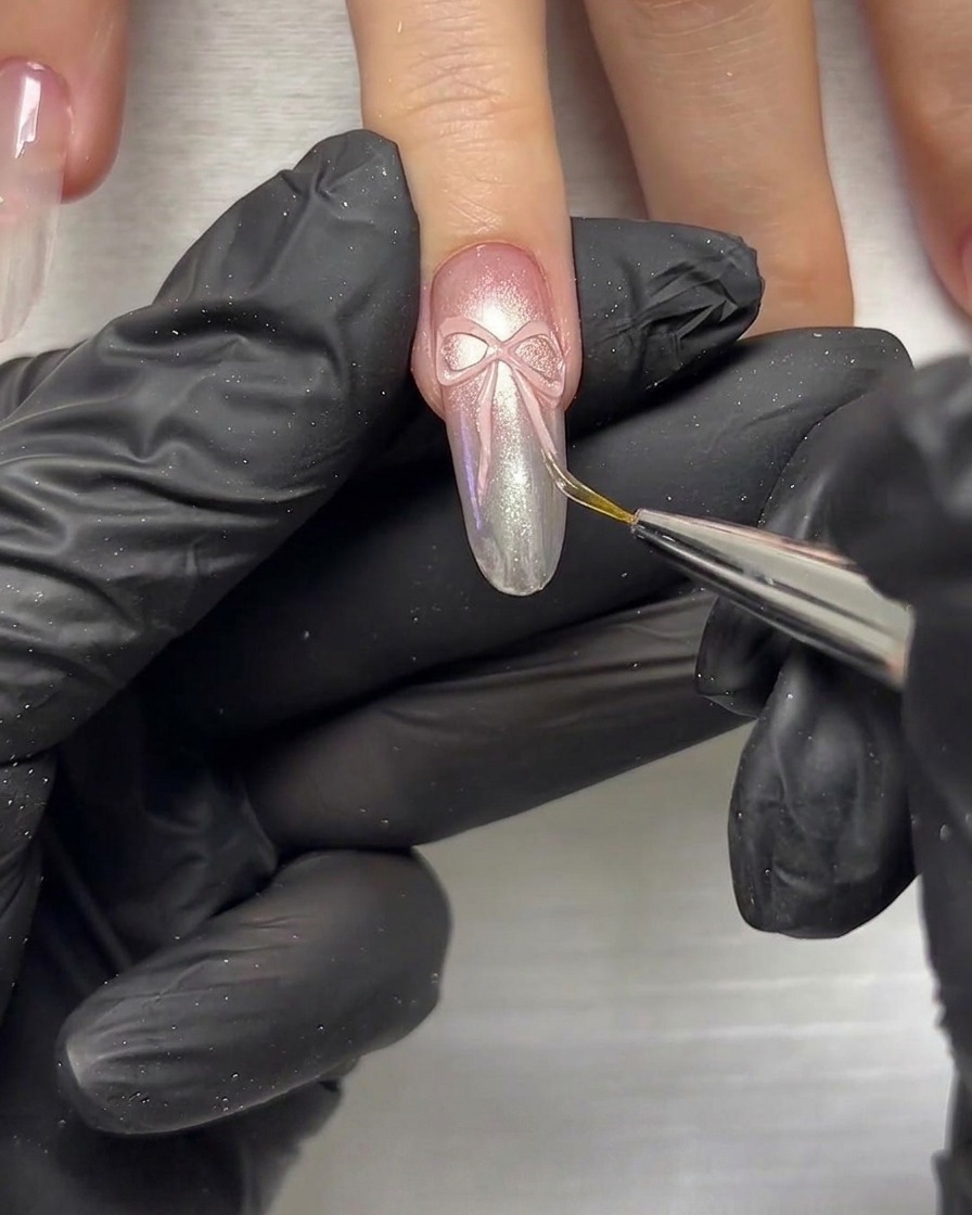 Nahaufnahme eines Detailwerkzeugs, das verwendet wird, um 3D-Schleifenelemente auf einem Nagel zu drücken und zu formen.