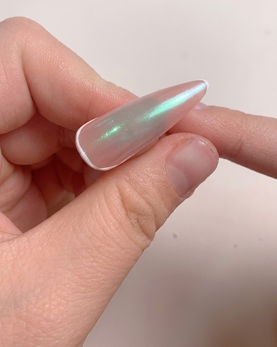 Un pennello applica uno strato di gel rinforzante sullunghia lucidata.
