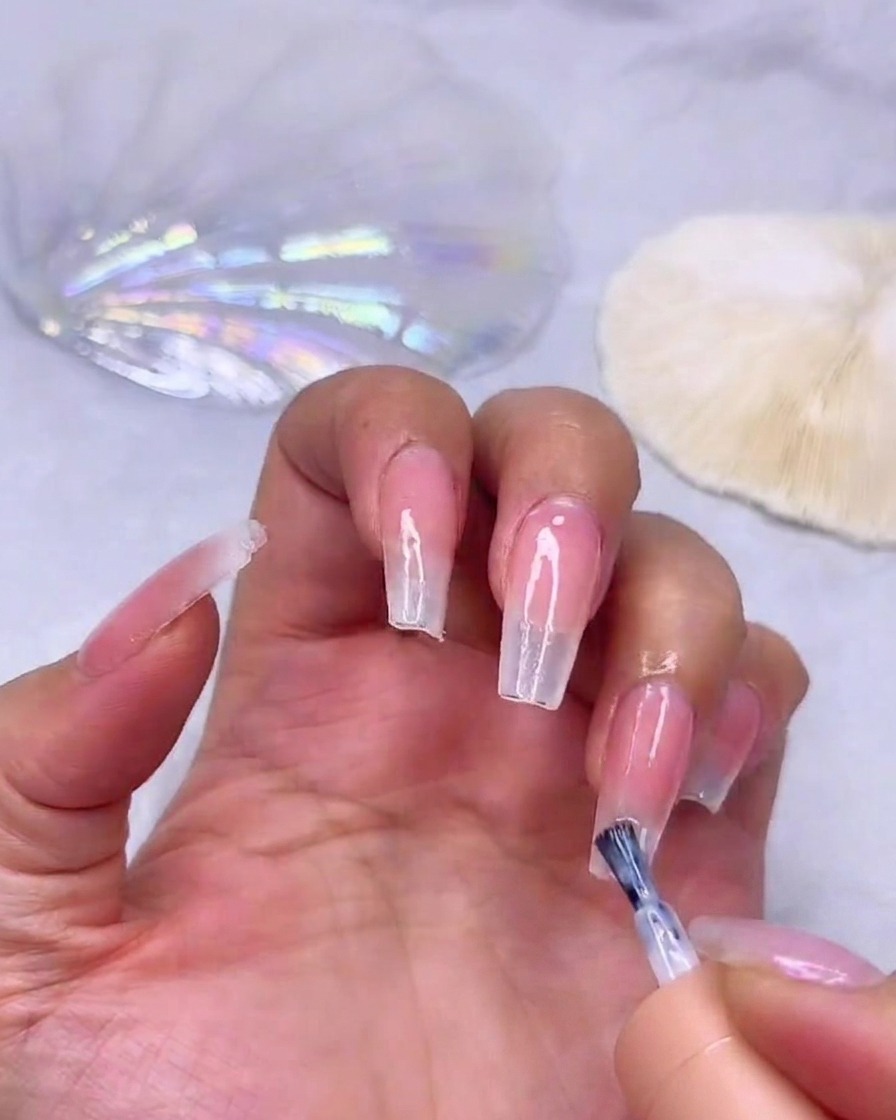 Applicazione di un terzo strato di gel bianco latte sulla punta estrema dellunghia per la massima coprenza.