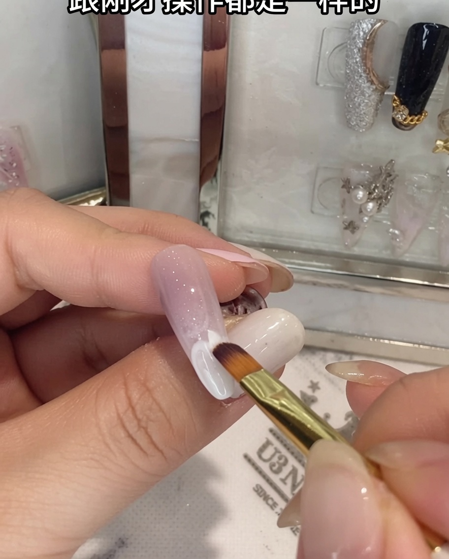 Un pennello che sfuma il gel bianco sulla metà inferiore di ununghia ombré.