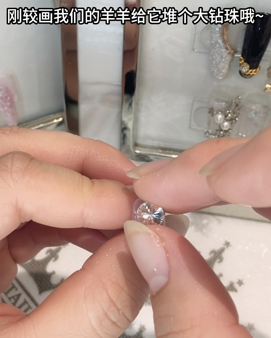 Un paio di pinzette che tengono e posizionano un grande strass di cristallo.