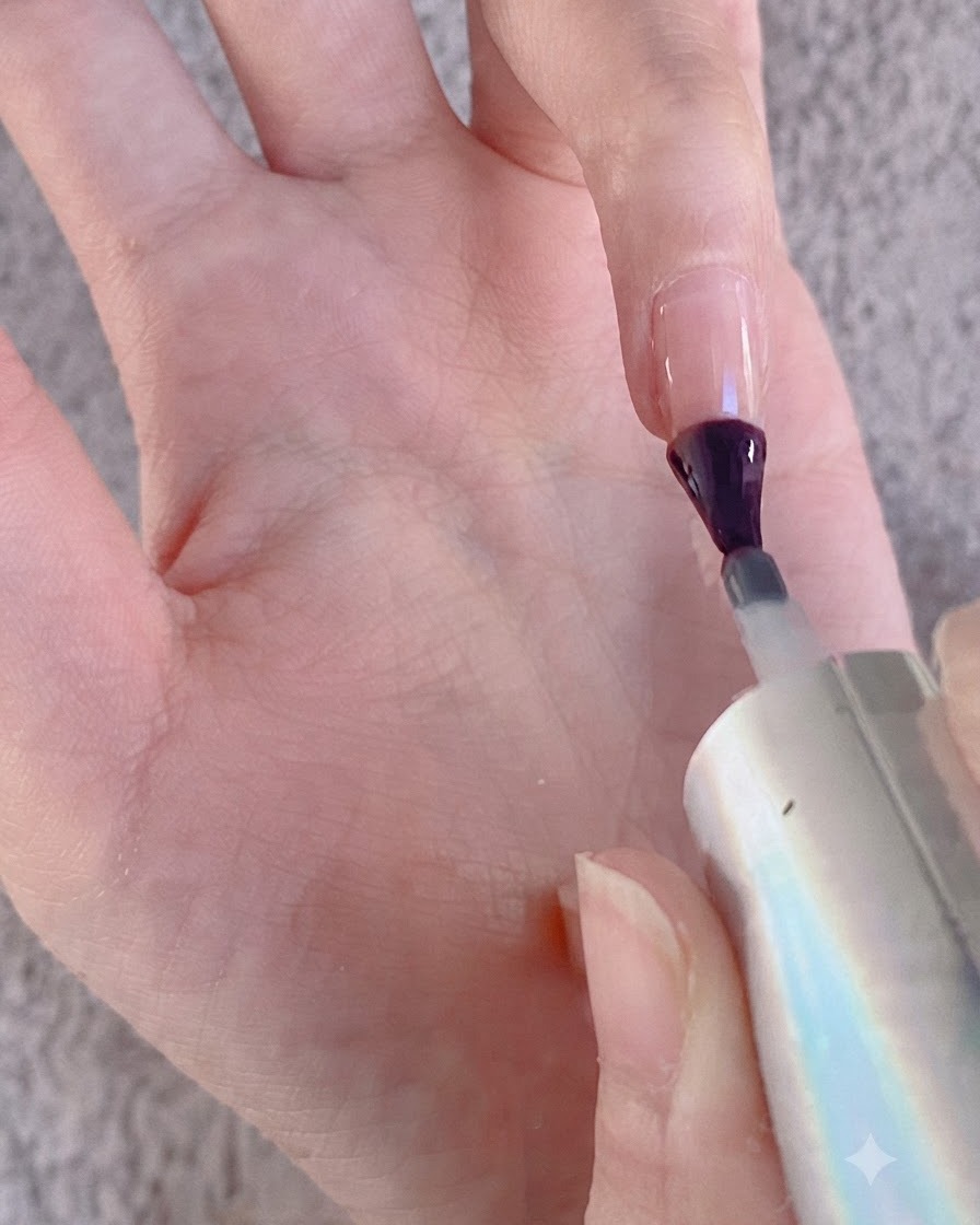 Un pennello da unghie che applica il gel sulla superficie di un dito in preparazione per la polvere cromata.