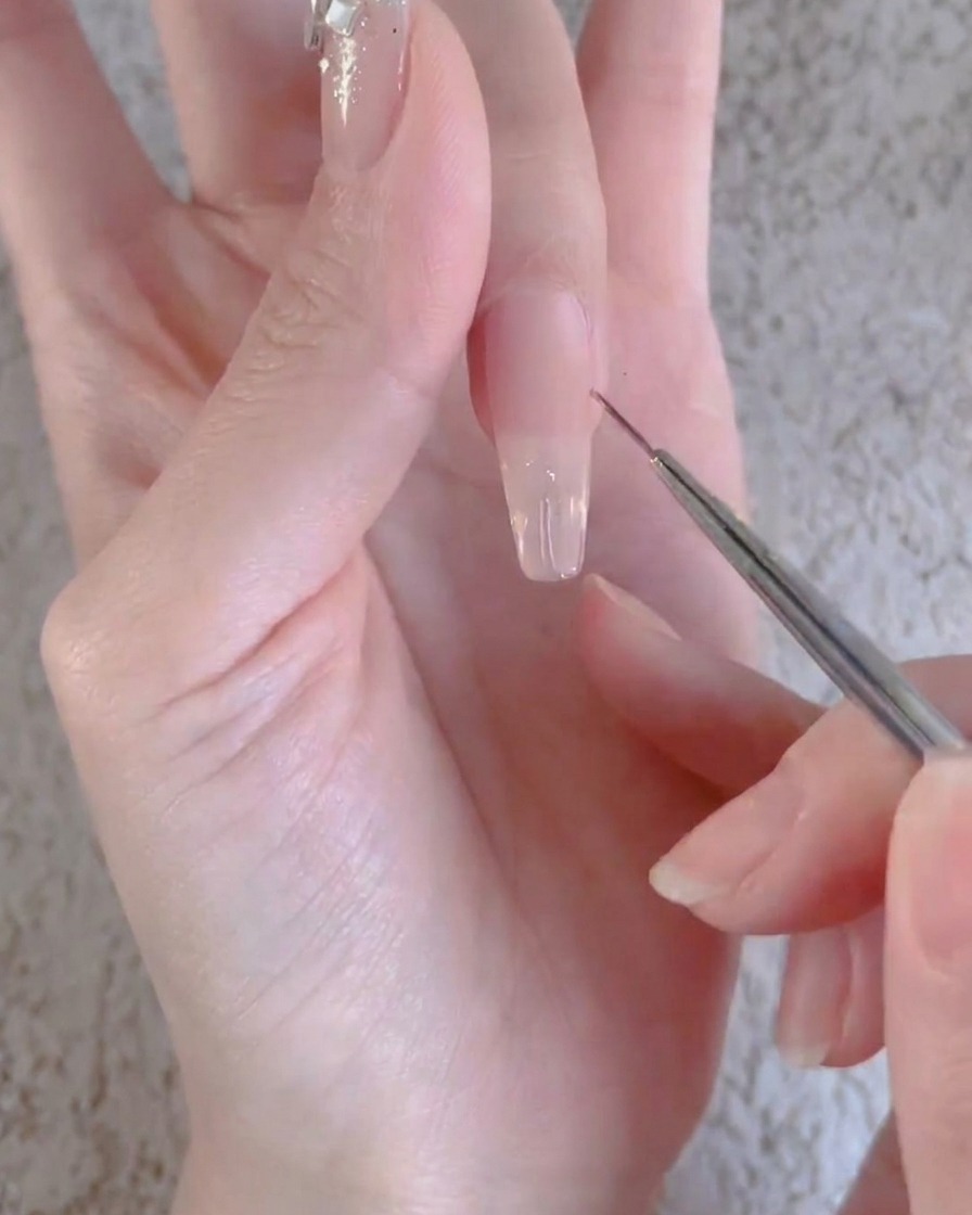 Un dito con uno strato di gel trasparente in fase di polimerizzazione sotto una lampada UV o LED professionale per unghie.