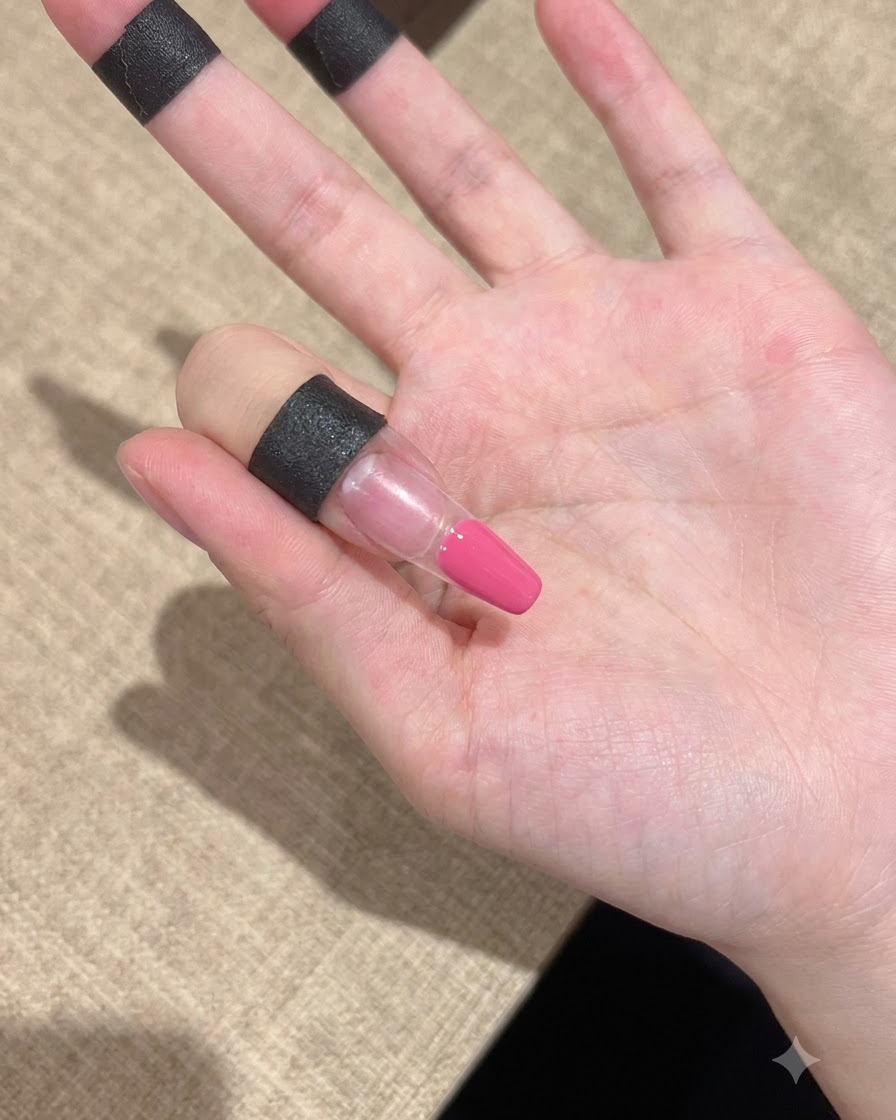 Primo piano di un dito con gel rosa applicato ordinatamente sulla zona della punta.