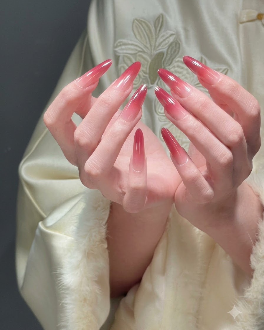 Due mani unite a coppa che presentano tutte le dita per mostrare una manicure ombré rossa festiva completa.