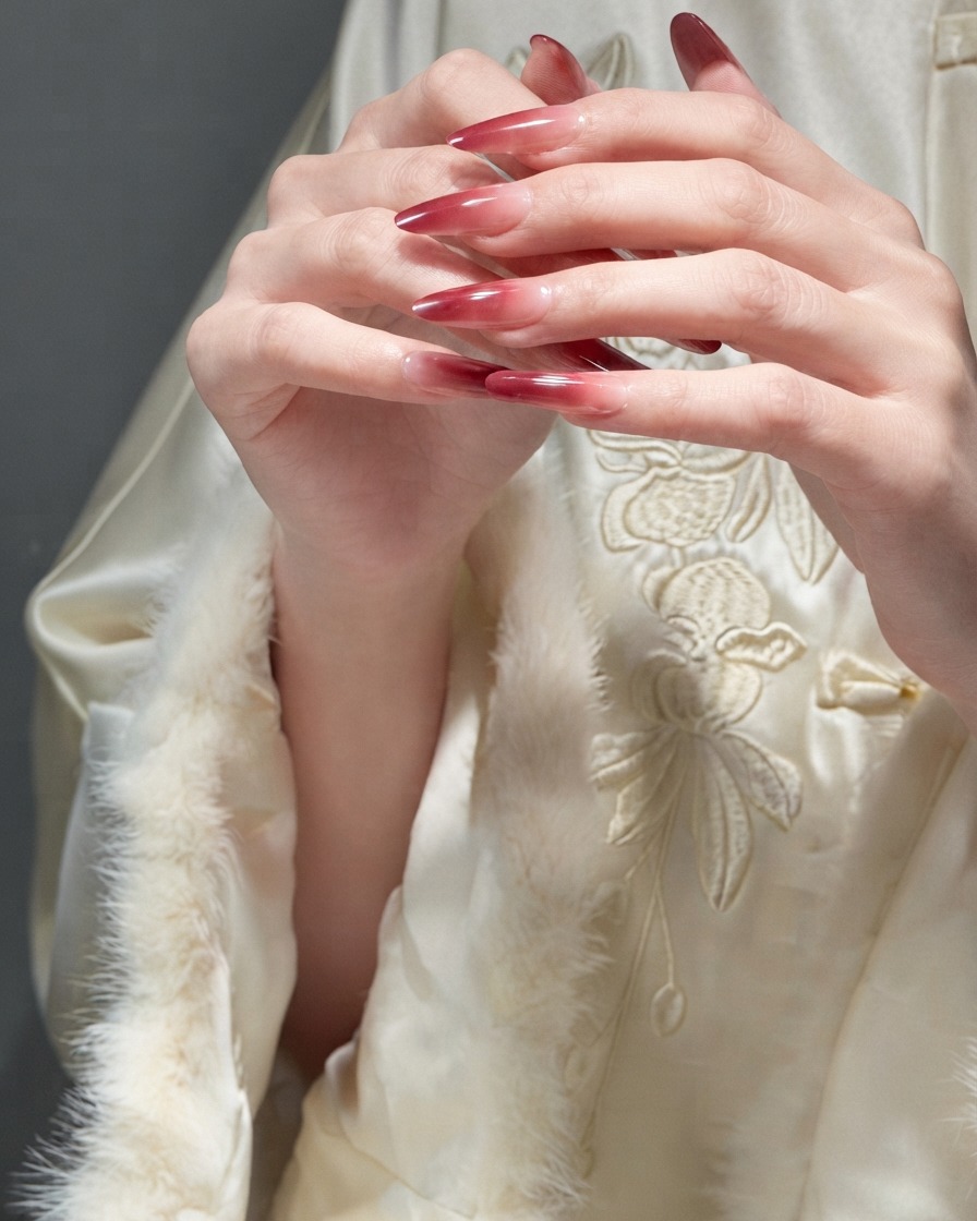 Dita che scivolano delicatamente luna sullaltra per dimostrare la consistenza liscia delle unghie in gel rosse finite.
