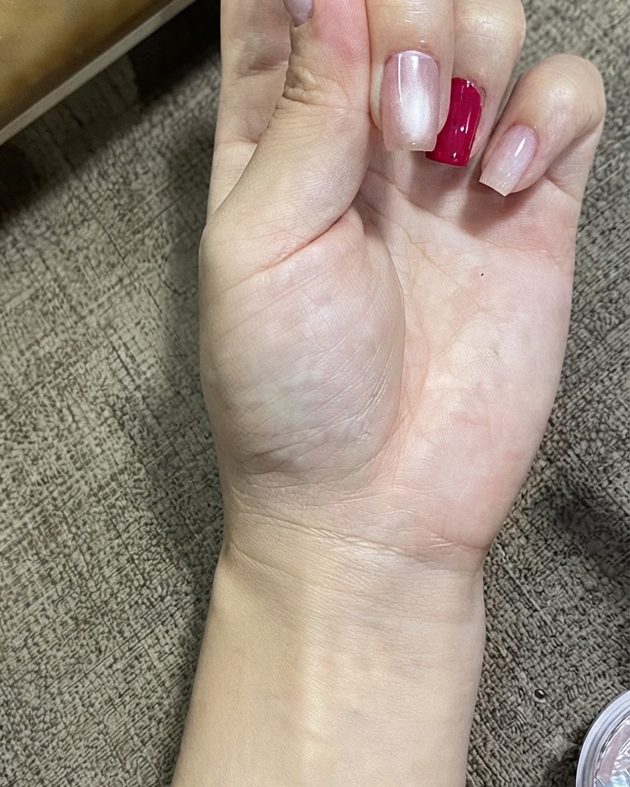 Vista ravvicinata di una mano che mostra unghie trattate con gel magnetico cat eye, con un luminoso effetto sfera di vetro.