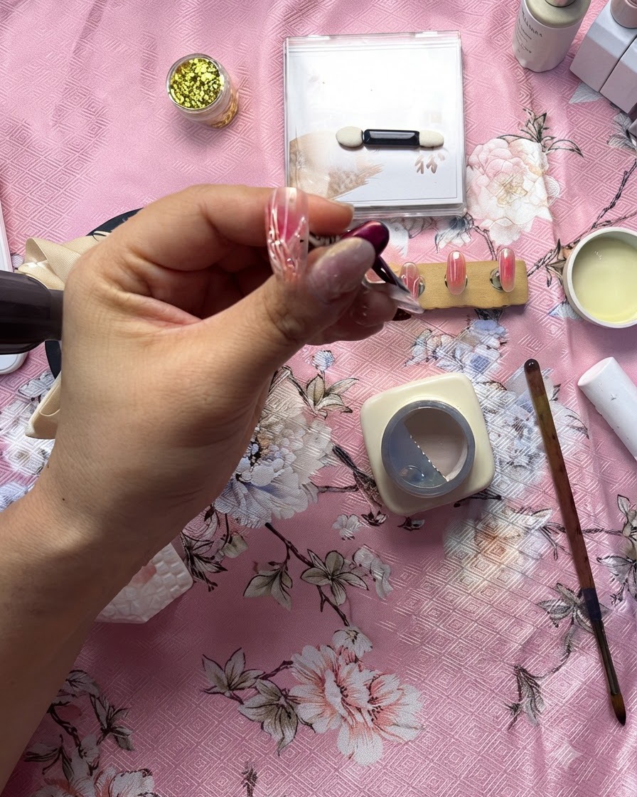 Un primo piano dettagliato di unonicotecnica che utilizza un pennello sottile per applicare una linea di gel trasparente in rilievo su un design a cuore bianco.