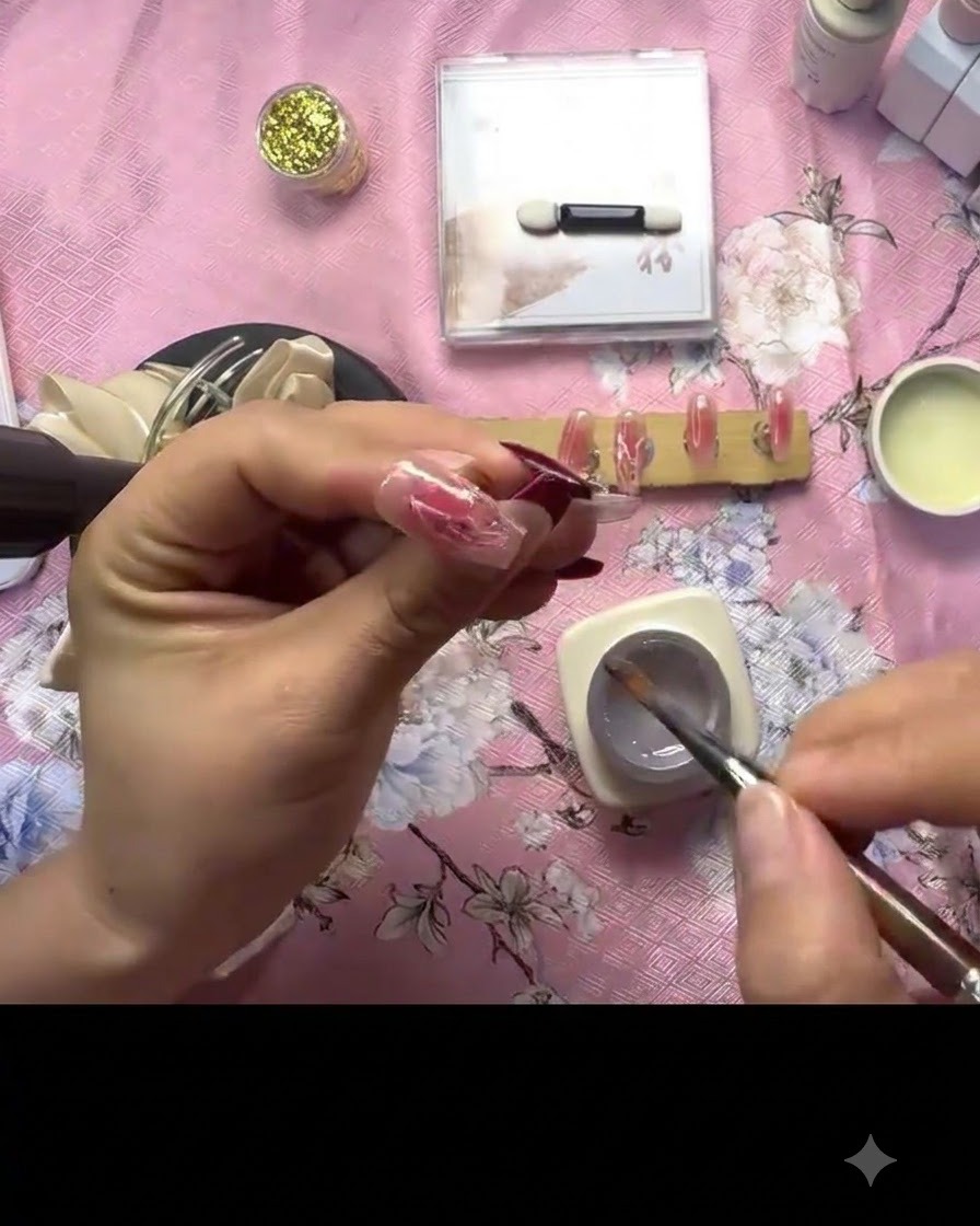 Una mano che tiene una mini lampada di polimerizzazione UV direttamente sopra ununghia decorata per fissare la texture in gel 3D.