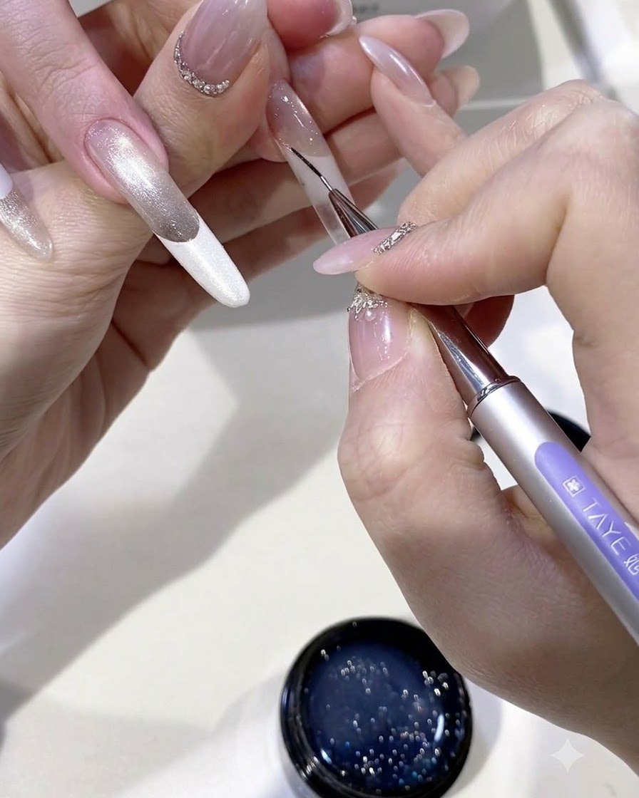 Un pennello a punta fine che disegna intricate linee di nappe con gel non polimerizzato sulla superficie dellunghia.