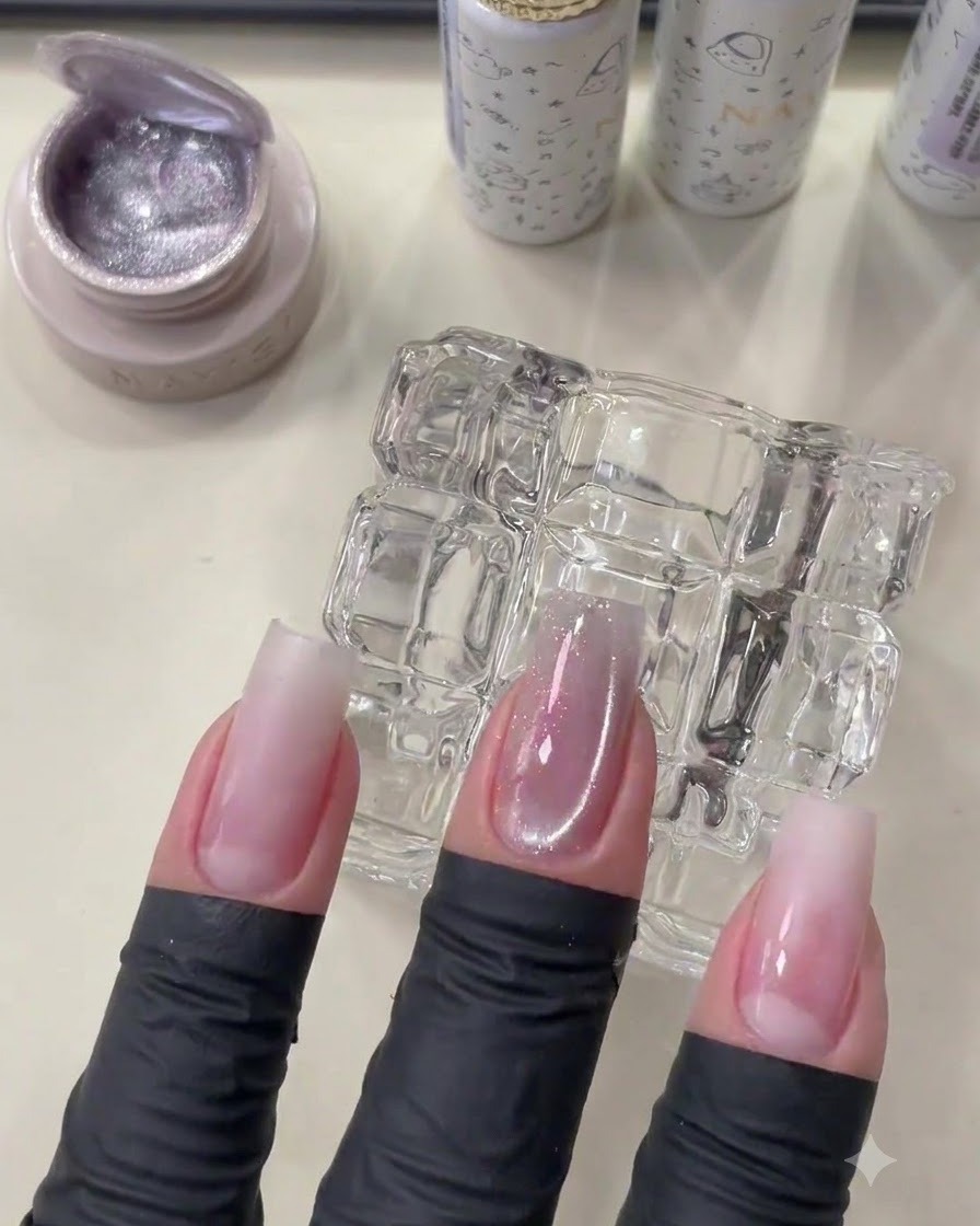 Una mano con unghie che mostra il gel cat eye polimerizzato con un morbido effetto brillante.