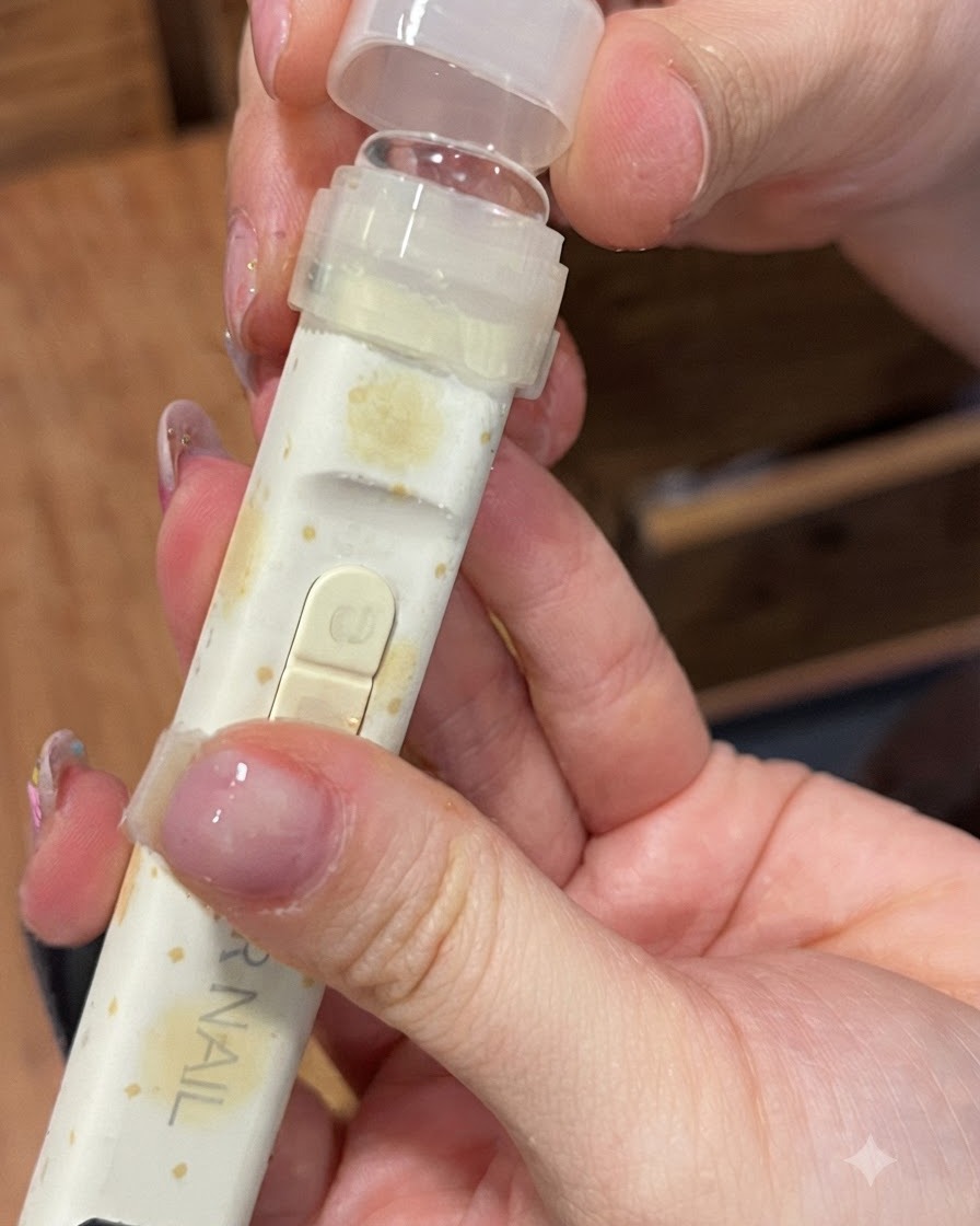 Una lampada portatile per unghie UV/LED dotata di una punta di pressione in silicone trasparente tenuta sopra un dito.
