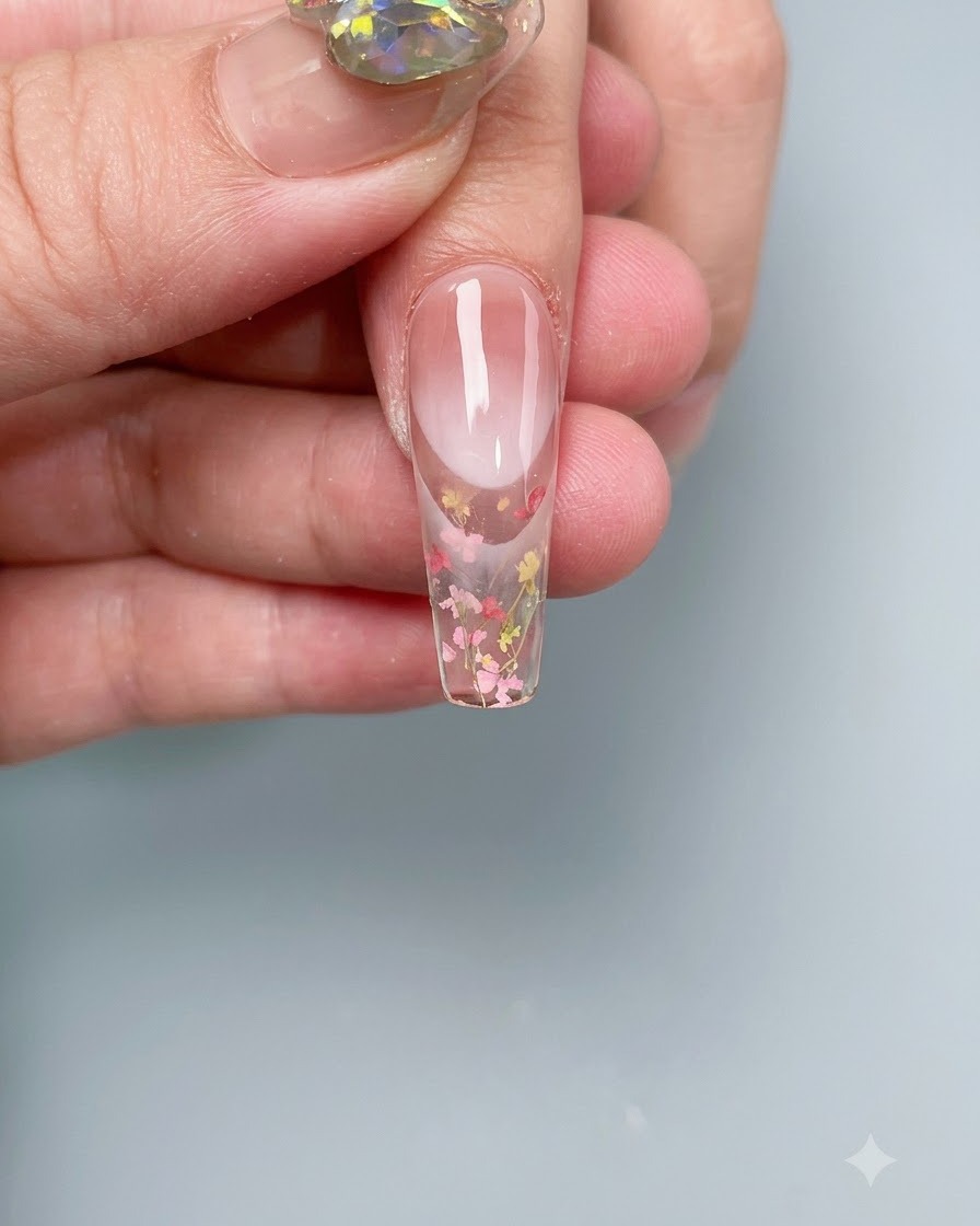 Ununghia con fiori secchi incorporati in fase di polimerizzazione allinterno di una lampada UV/LED professionale.