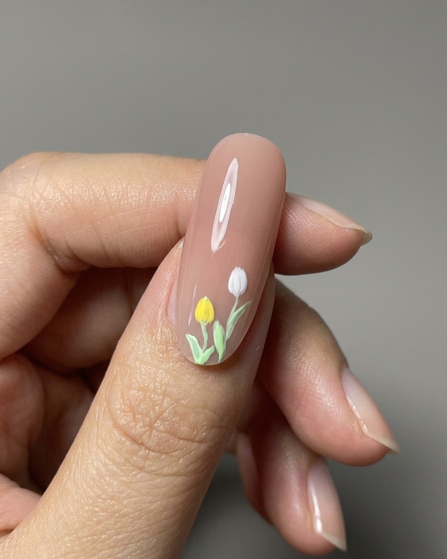 Primo piano di tulipani dipinti in 3D finiti su ununghia nude lucida.