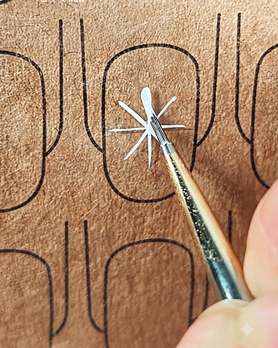 Un pennello fine che crea il primo tratto di un petalo bianco verso lesterno dal centro delle linee guida.