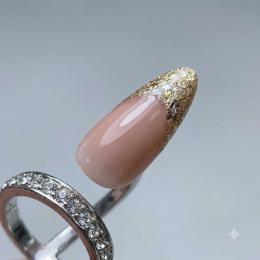 Primo piano di un pennello per unghie che applica gel platino per formare una linea guida per French tip su ununghia curata.